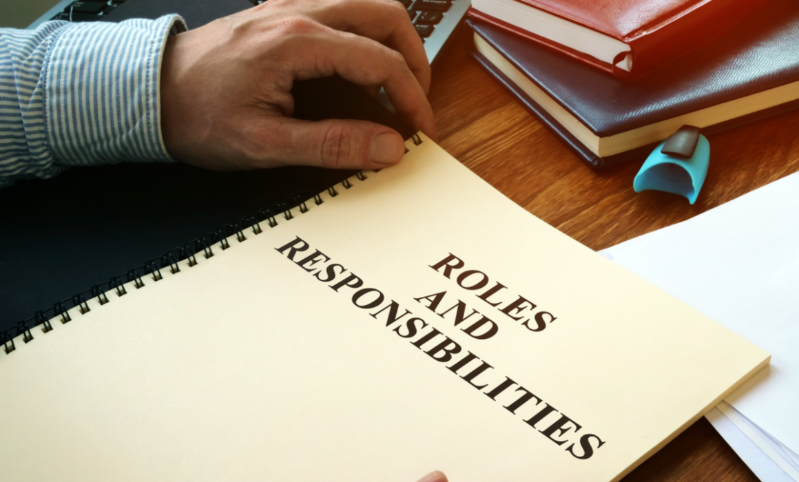 Man holding a book about roles and responsibilities
