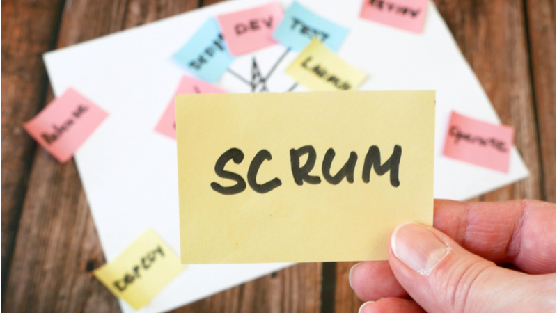 Man holding sticky note saying scrum